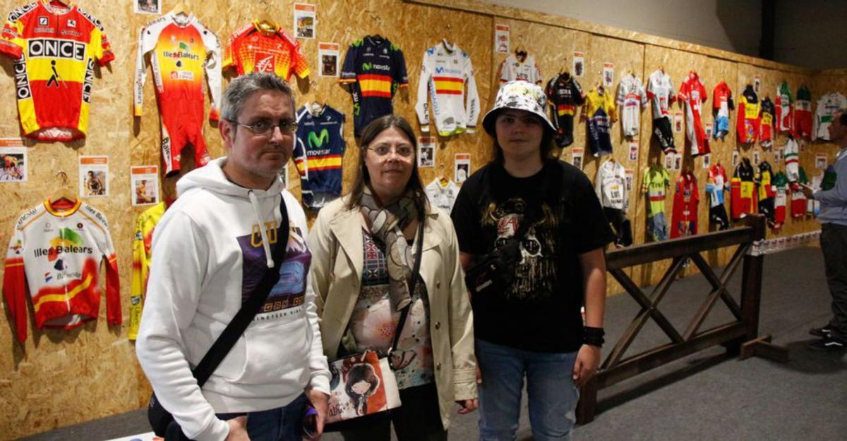 Ángel Díaz y María Victoria Berdasco con su hijo, Raúl, junto a los maillots históricos que componen la muestra «Campeones de bandera».