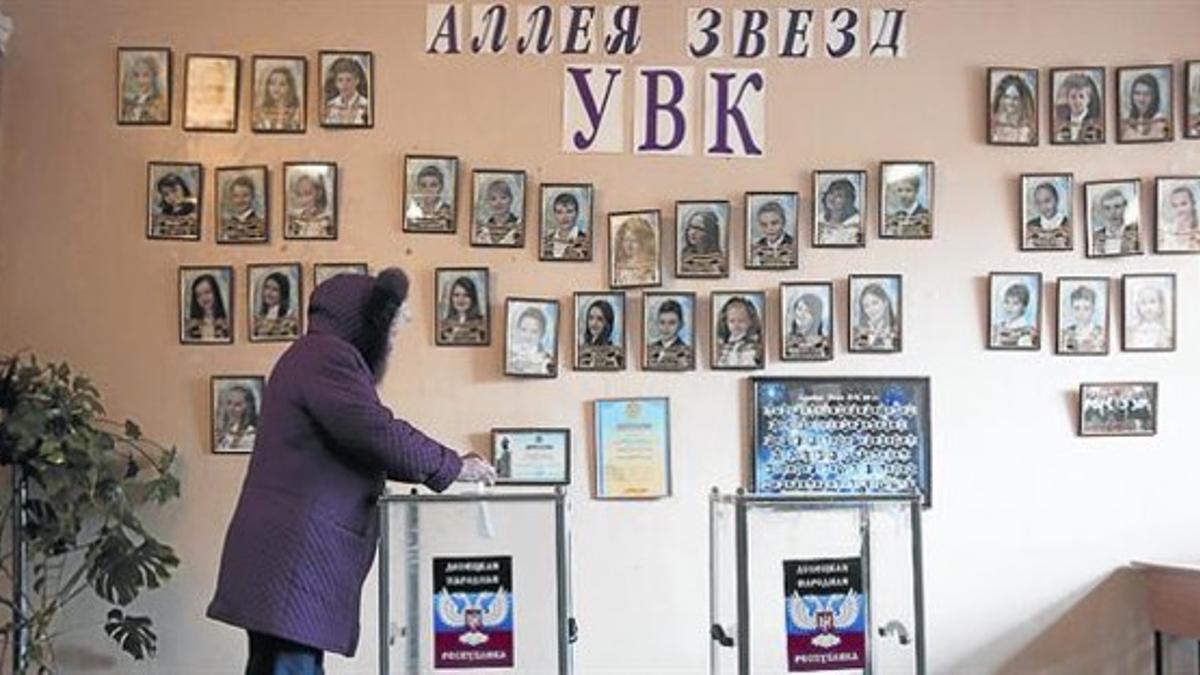 Una mujer deposita su voto en un colegio electoral en Donetsk, en las elecciones de ayer.