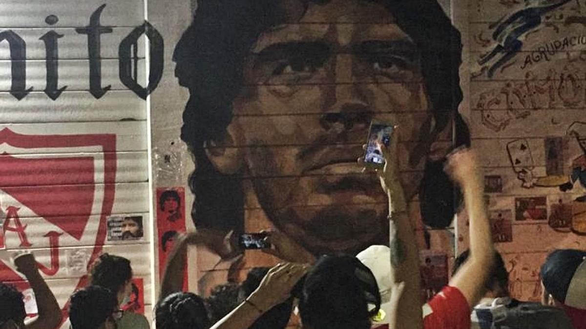 Seguidores de Diego Armando Maradona fotografían un mural con su retrato. | Cedida