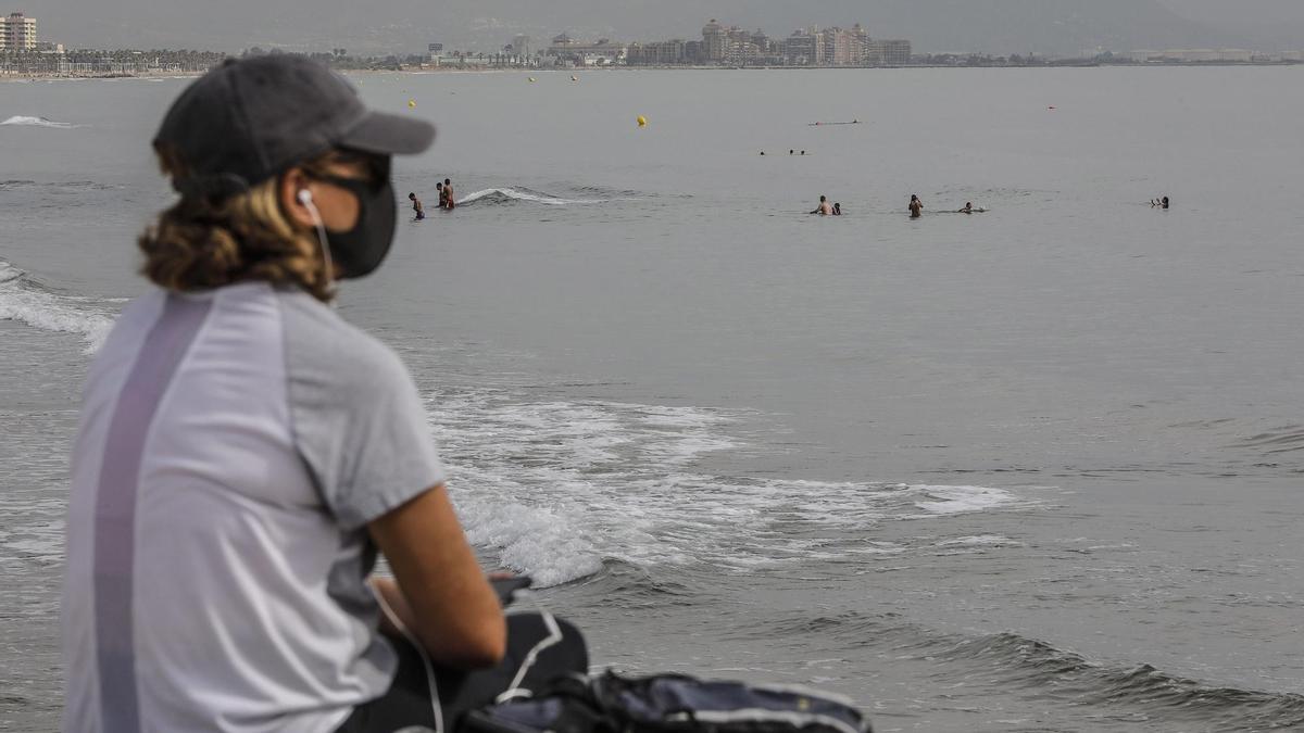 Una mujer con mascarilla en la Playa de la Malvarrosa de Valencia.