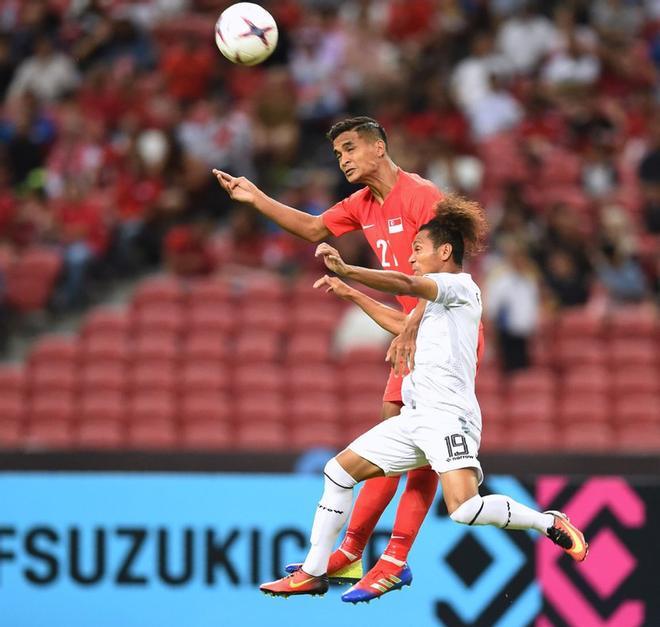 El defensa Safuwan Baharudin (C) lucha por el balón con el mediocampista de Timor Oriental Feliciano Goncalves (R) durante el partido de fútbol de la Copa Suzuki de la AFF de 2018 entre Singapur y Timor Oriental en el Estadio Nacional.