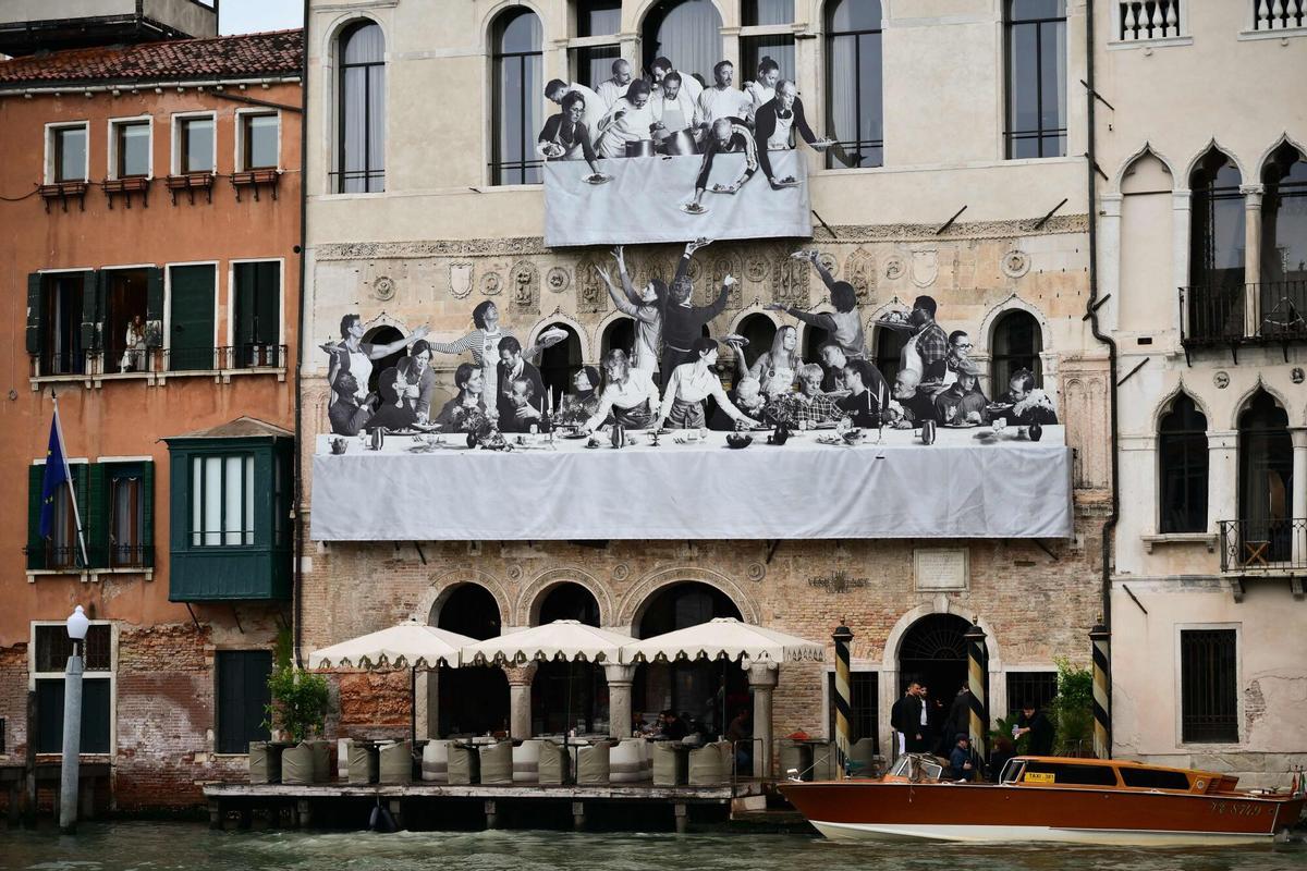 Una fotografía muestra “Il Gesto”, del artista francés JR, en la fachada de Ca' del Mosto, cerca del puente de Rialto, durante la 61ª Bienal de Arte de Venecia.