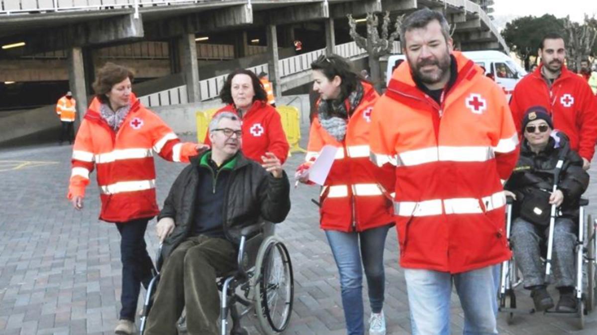 Voluntarios de la Cruz Roja ofreciendo el servicio 'Te Acompañamos' a socios del Barça
