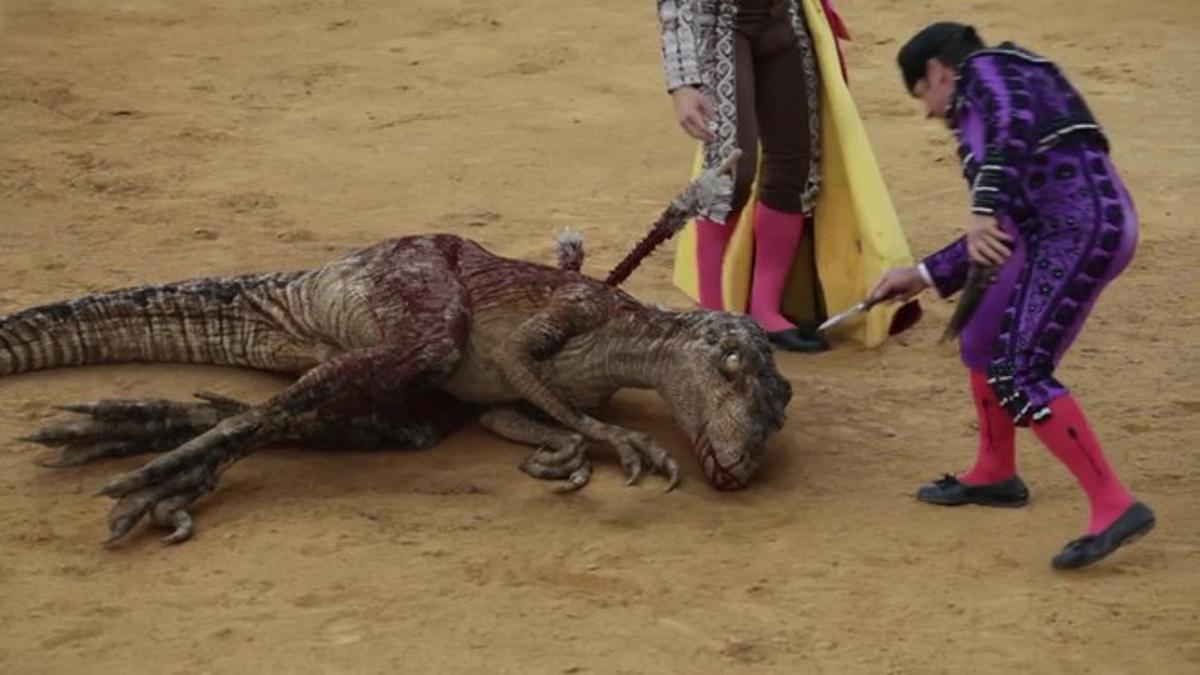 Un velociraptor es toreado, banderilleado y estoqueado en una plaza por un matador y su cuadrilla.