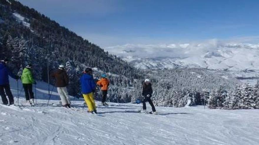 Esquiadors en una de les pistes de Masella aquest hivern amb la Cerdanya nevada al fons