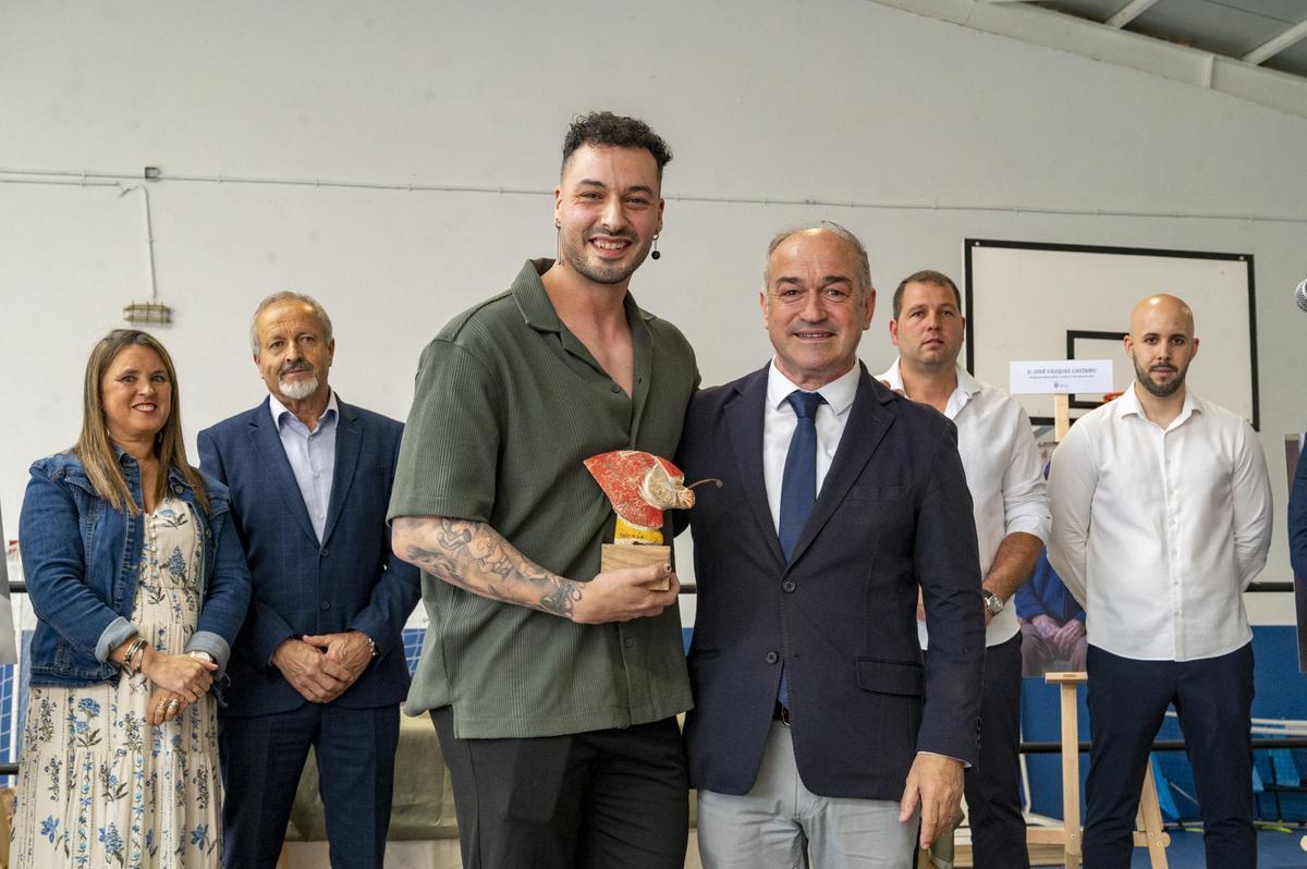 O docente e influencer Gabi García Calvo sostén o recordo que lle entregou o rexedor, ao seu carón