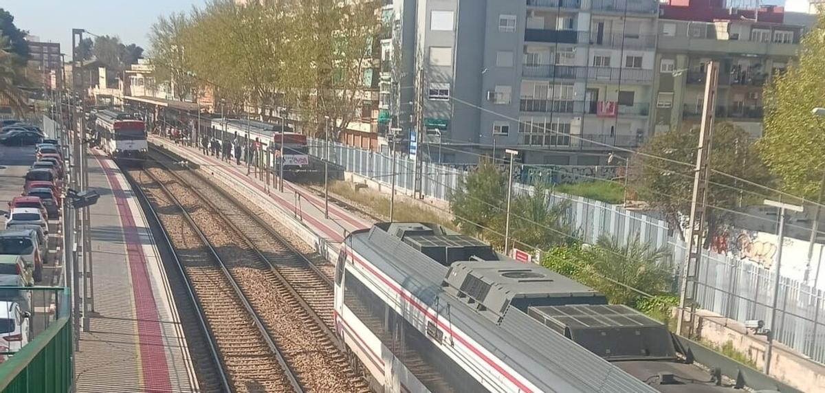 Trenes parados y los usuarios en los andenes en la estación de Alfafar.
