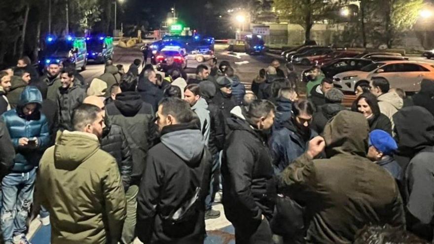 Trabajadores y furgones policiales a la entrada de la planta.