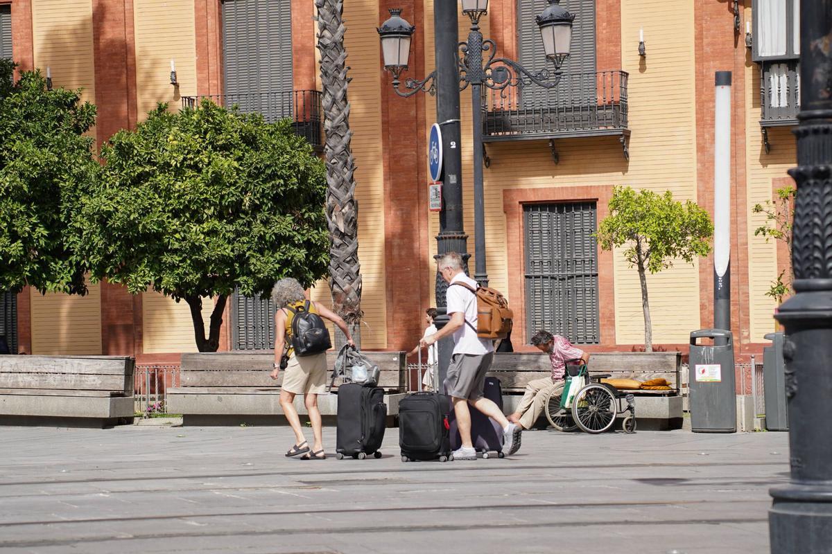 Turistas con maletas y equipaje en el centro de Sevilla
