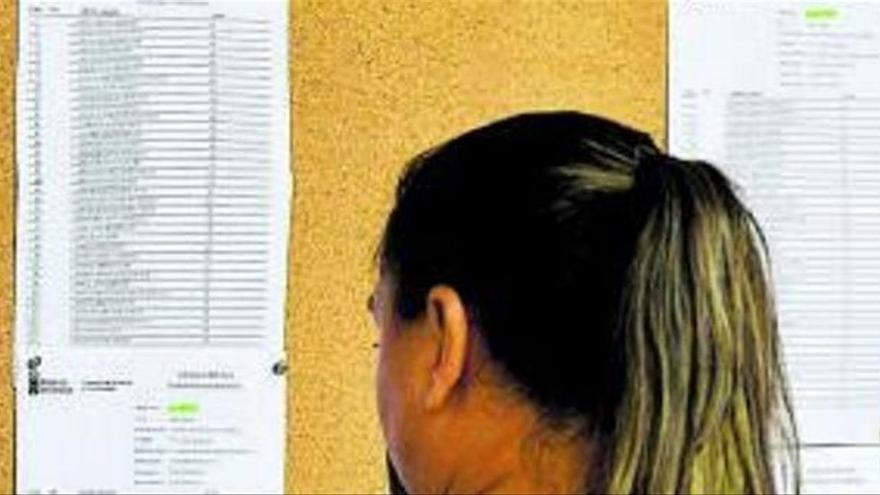 Una mujer comprueba las listas de aprobados en unas oposiciones.