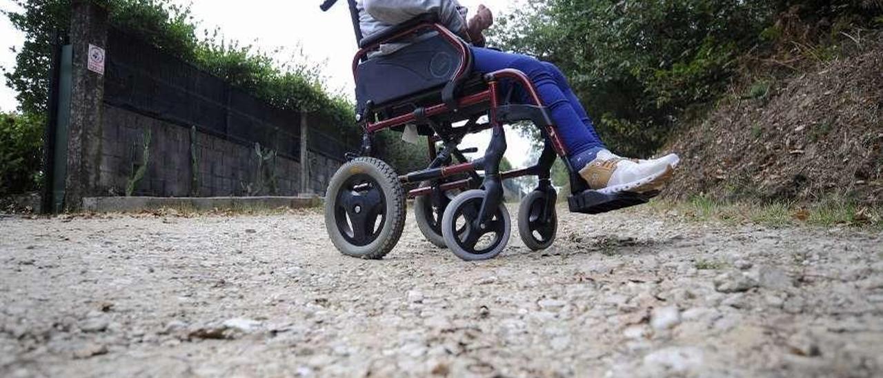 Florinda Blanco, ayer, en su silla de ruedas en el camino de acceso a su vivienda. // Bernabé/Javier Lalín