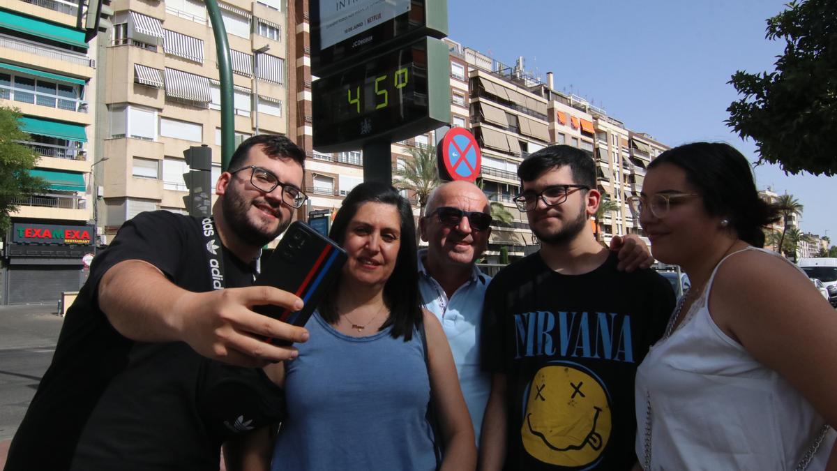Un grupo de personas se hace un &#039;selfie&#039; este domingo con un termómetro que marca 46º este domingo en Córdoba.