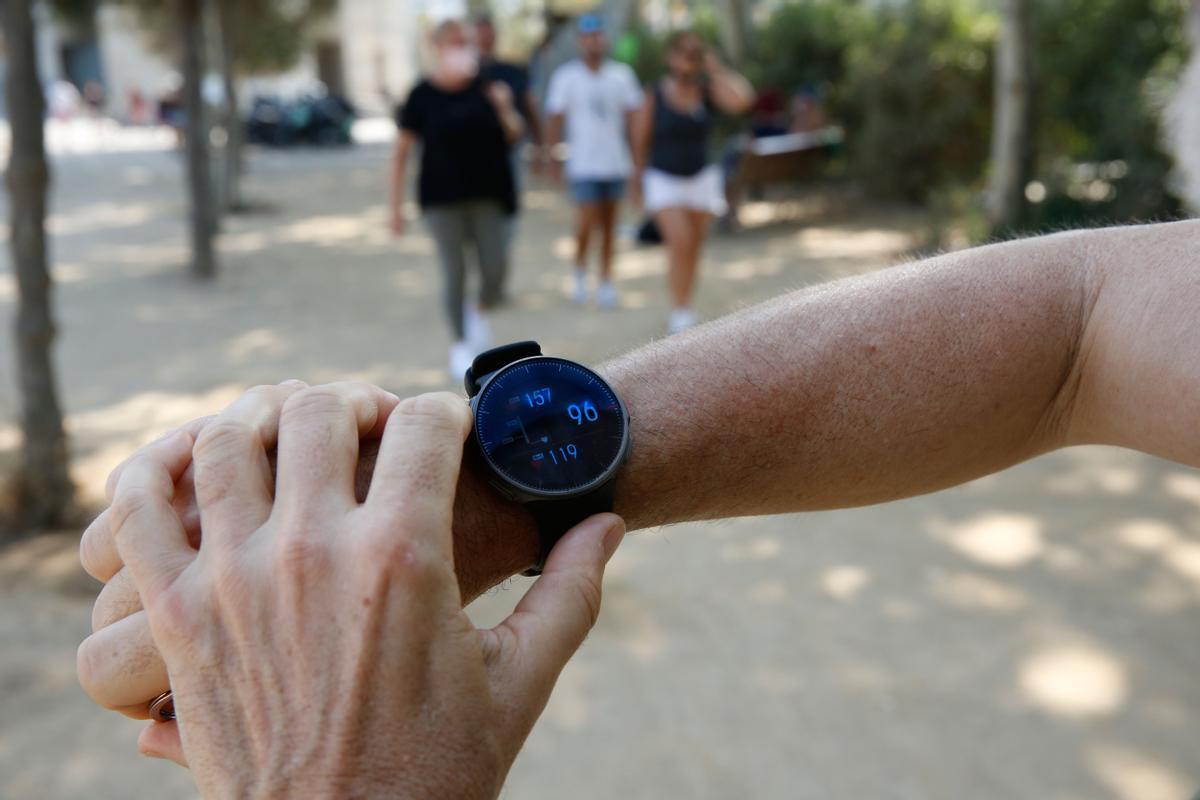 Un hombre mira las funciones biomédicas de su reloj inteligente.