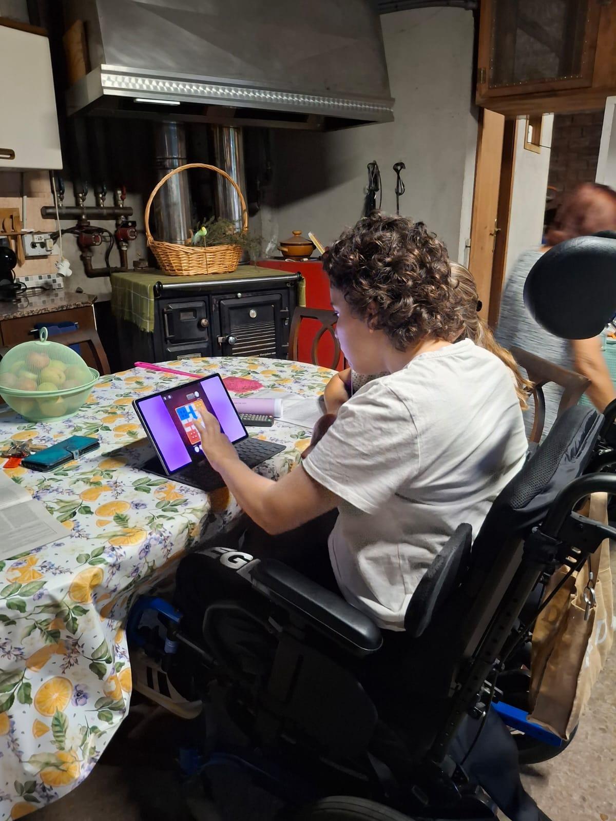 Yesenia ya juega al parchís en su tablet sentada a la mesa.
