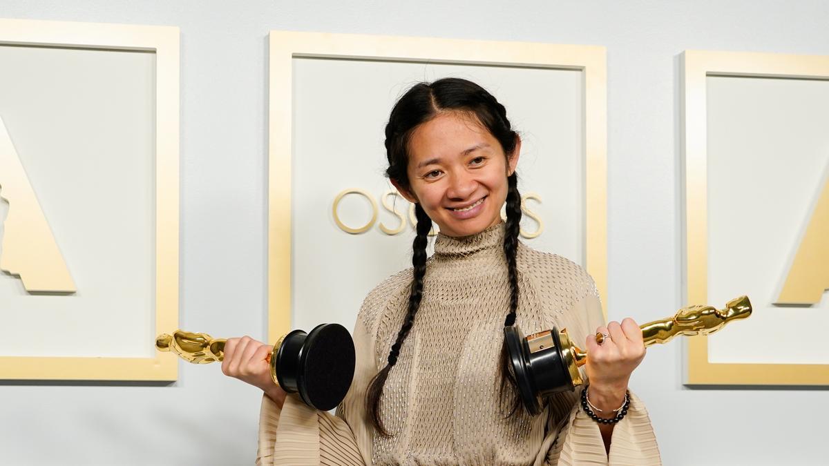 Una imagen de la directora china Chloé Zhao posa con dos estatuillas.