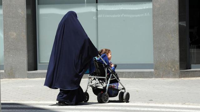 Una mujer musulmana pasea a su hija.