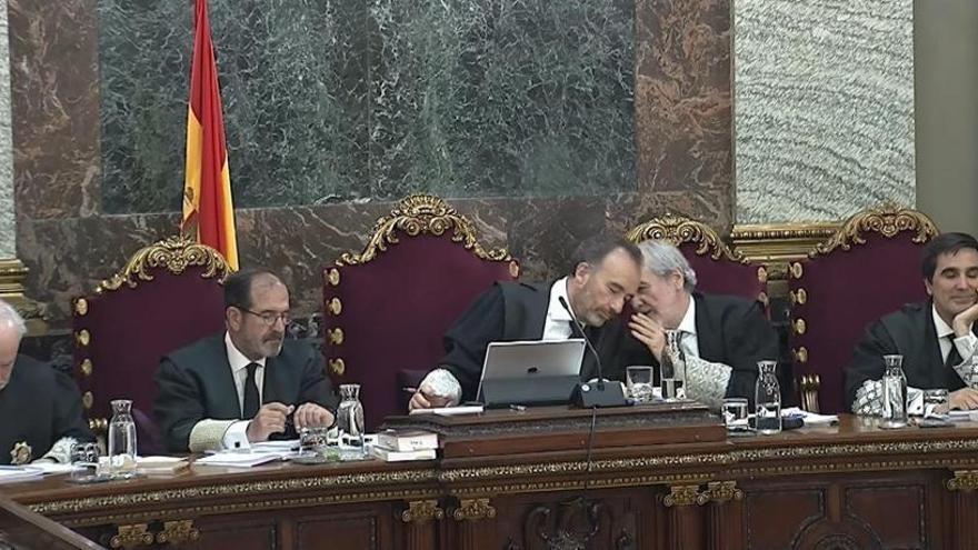 Marchena mientras conversa con el juez Juan Ramón Verdugo (2d).