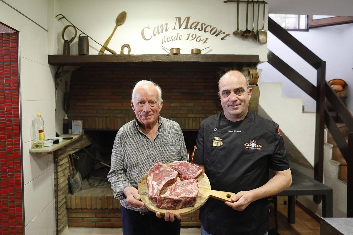 Àngel i Jordi Mascort, pare i fill, davant la brasa del restaurant.