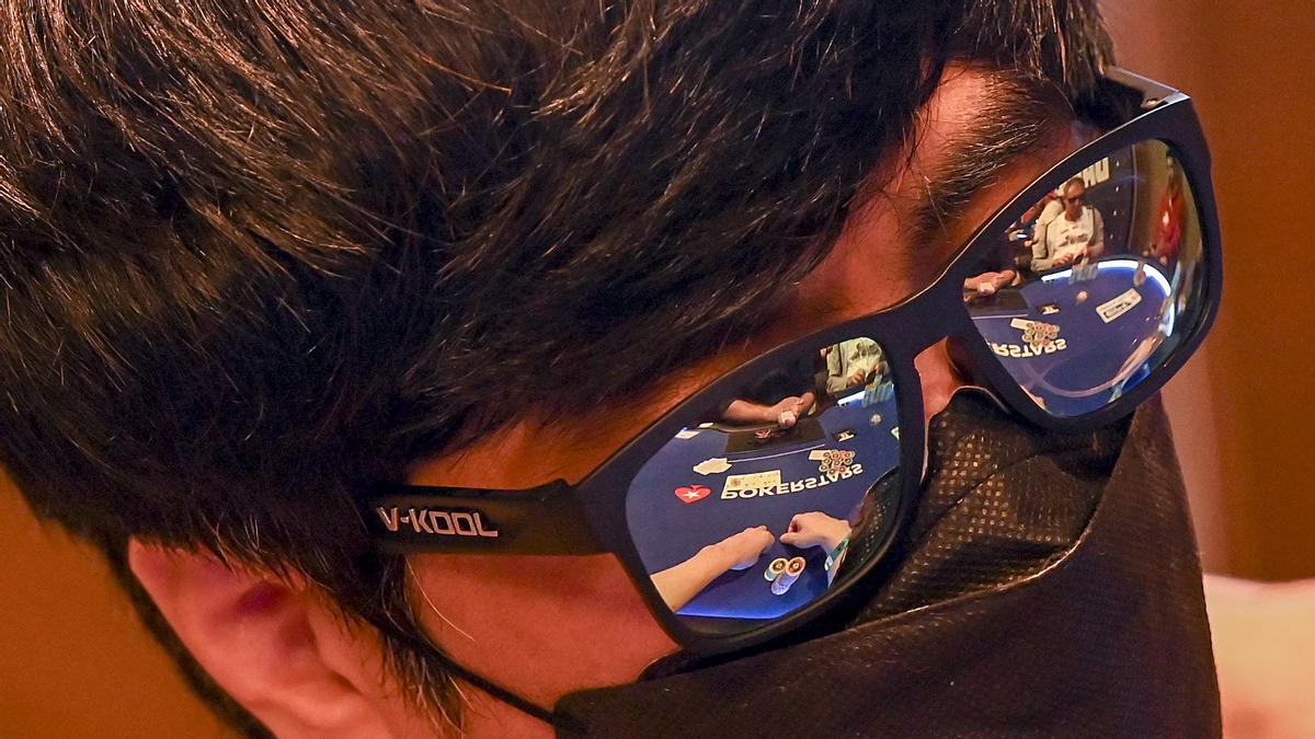 El juego de una mesa reflejado en las gafas de un jugador.