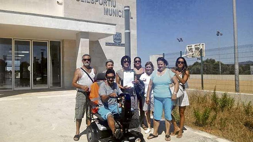 Vecinos ante el polideportivo municipal de Cala d´Or, ayer, con las hojas de la campaña de recogida de firmas.