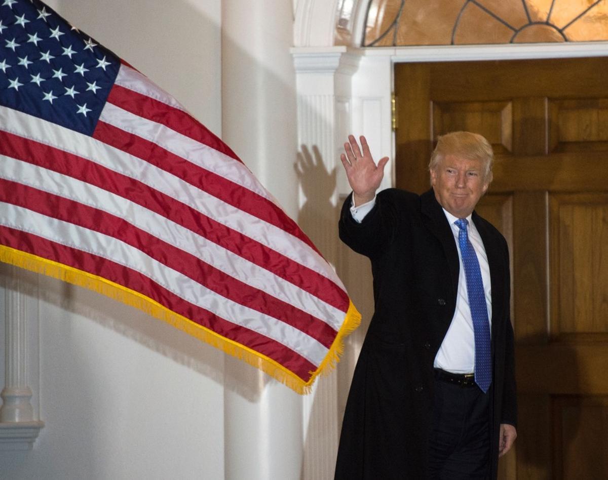 TOPSHOT - President-elect Donald Trump waves to the media from the steps at the clubhouse of Trump National Golf Club November 20, 2016 in Bedminster, New Jersey. / AFP PHOTO / DON EMMERT