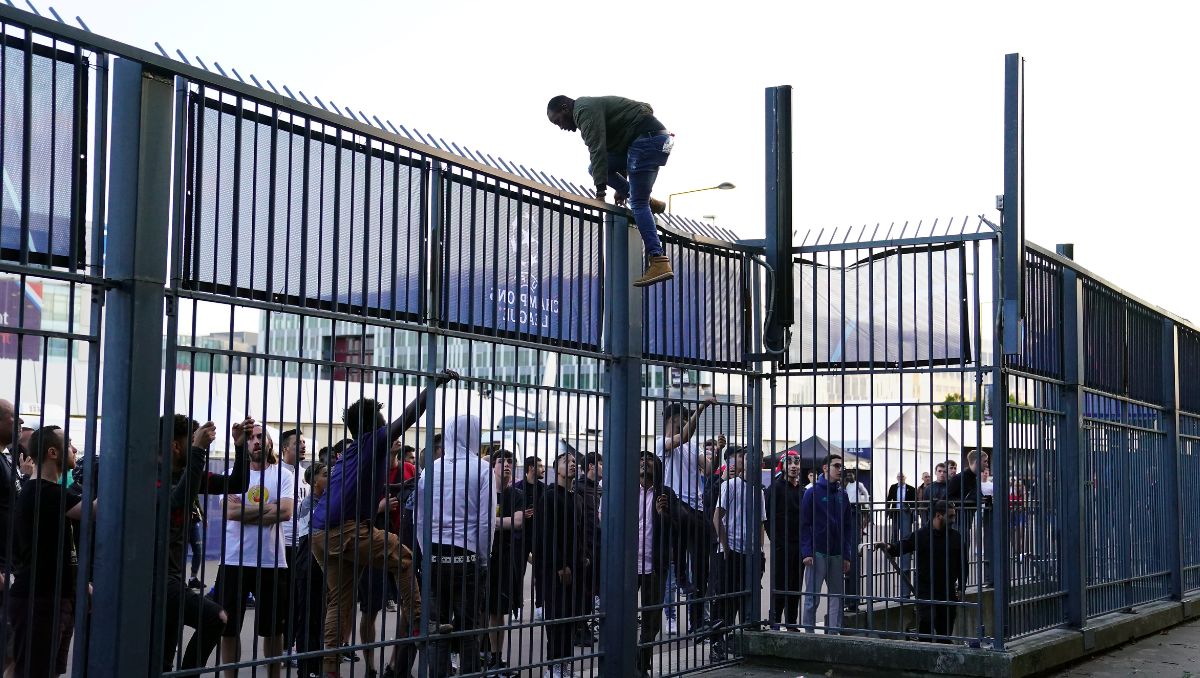 Varias personas intentan saltar una valla del Stade de France durante la final de la Champions en Paris, este sábado.