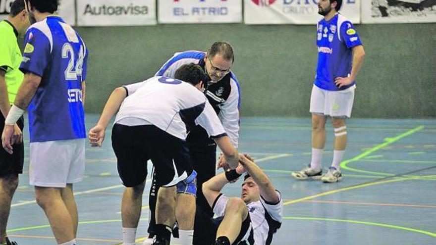 Juan Muñiz ayuda a levantarse a uno de sus jugadores en un encuentro liguero.