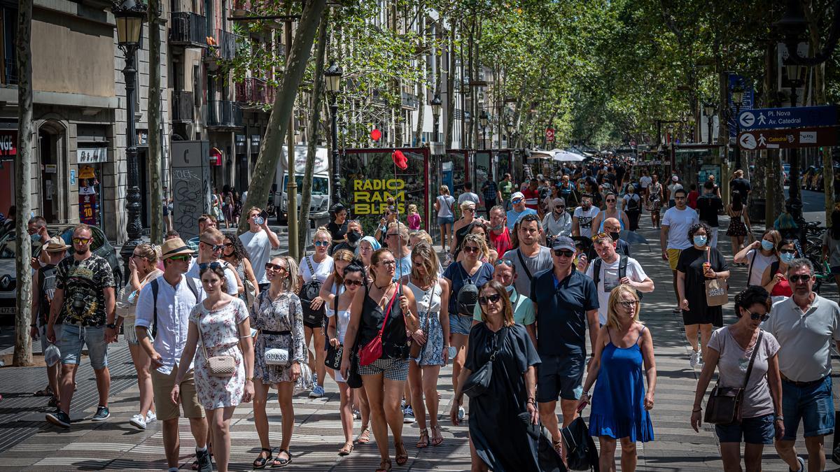 Turistas paseando por la rambla de Barcelona.