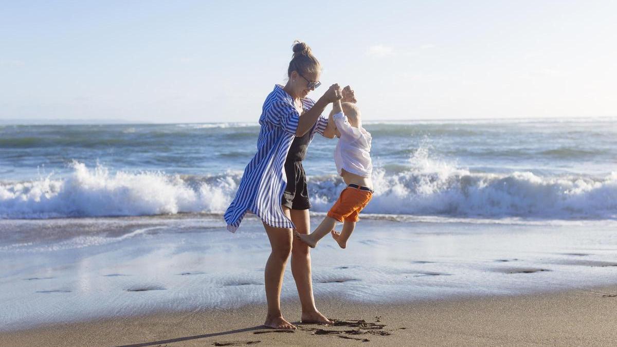 Una madre en la playa con su hijo.