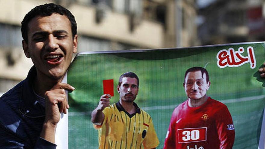 Un manifestante muestra una pancarta en la que se ve un árbitro sacando la tarjeta roja al presidente egipcio Hosni Mubarak, este domingo en El Cairo