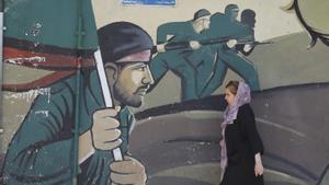 Teherán, Irán 14/04/2024.- Una mujer iraní camina junto a una pintura de la Guardia Revolucionaria Iraní (IRGC) 