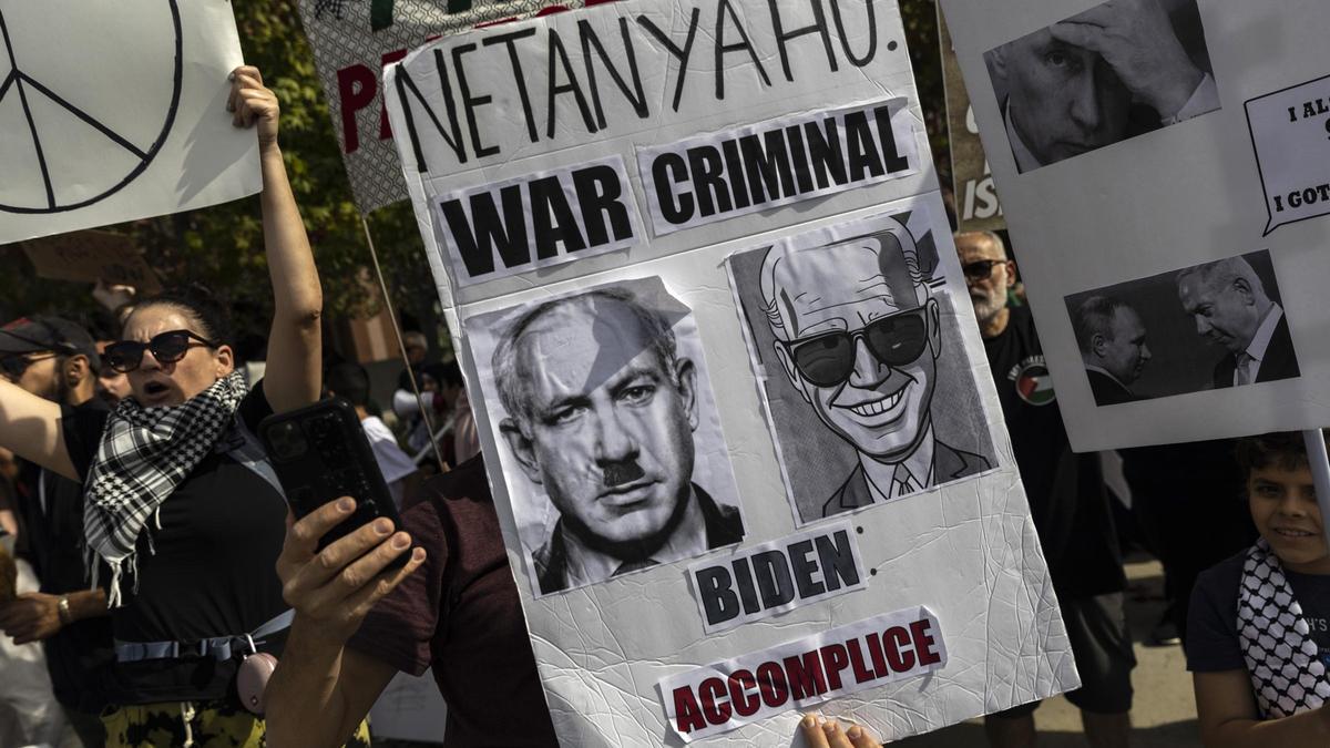 Un manifestante muestra un cartel acusando a Netanyahu de criminal de guerra y a Biden de cómplice, durante una protesta en apoyo al pueblo palestino en Los Ángeles, este sábado.