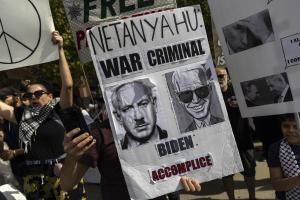 Un manifestante muestra un cartel acusando a Netanyahu de criminal de guerra y a Biden de cómplice, durante una protesta en apoyo al pueblo palestino en Los Ángeles, este sábado.