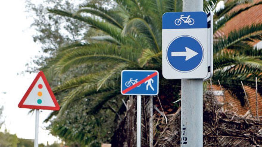 La señal de tráfico recomienda que ciclistas y peatones vayan por la senda oscura.