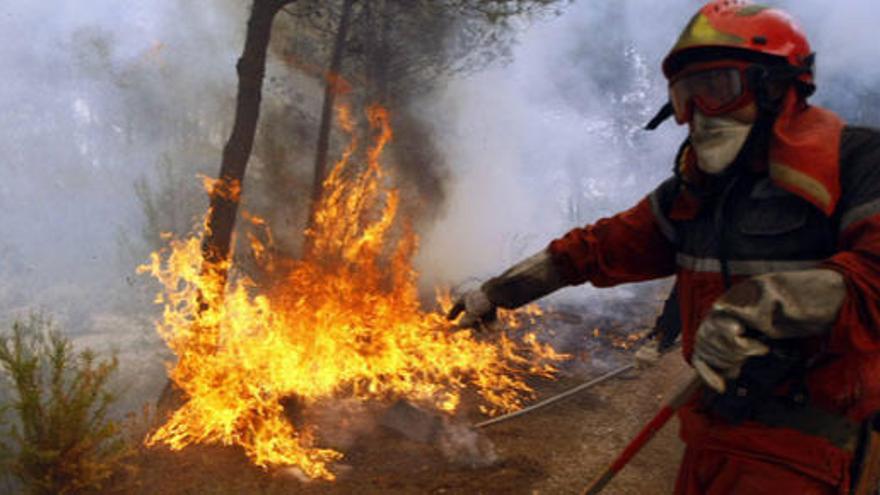 Un bombero trata de apagar un fuego cerca de Alicante.