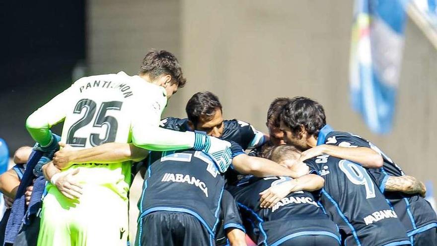 Los jugadores del Deportivo forman una piña sobre el césped de Cornellá.