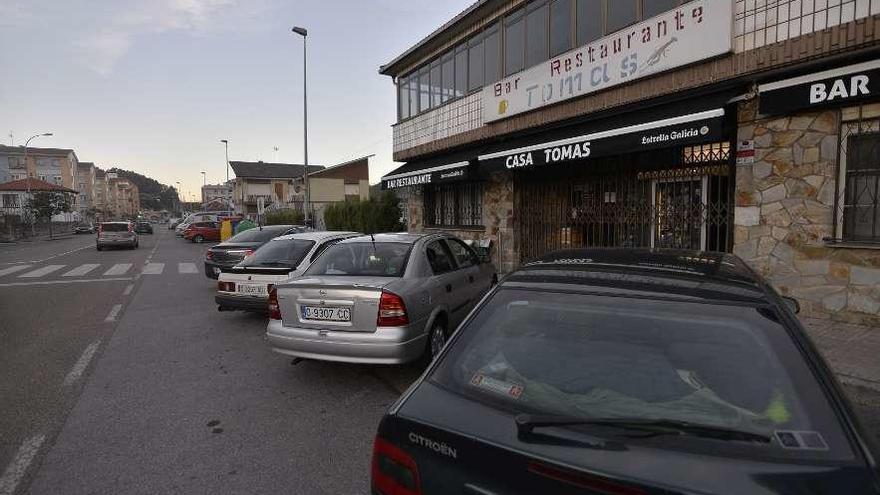 Varios coches aparcados en la carretera general que cruza la parroquia de Cancienes.