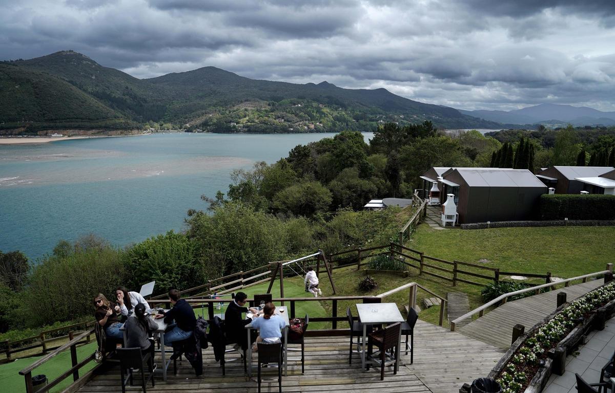 Turistas en un restaurante con vistas a la marisma de la Reserva de la Biosfera de Urdaibai.