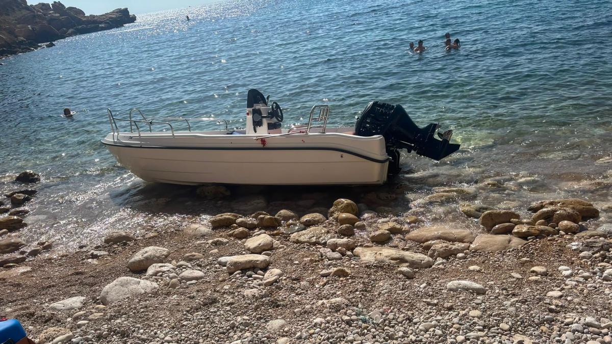 La patera ha quedado embarrancada en la orilla de piedras de esta cala