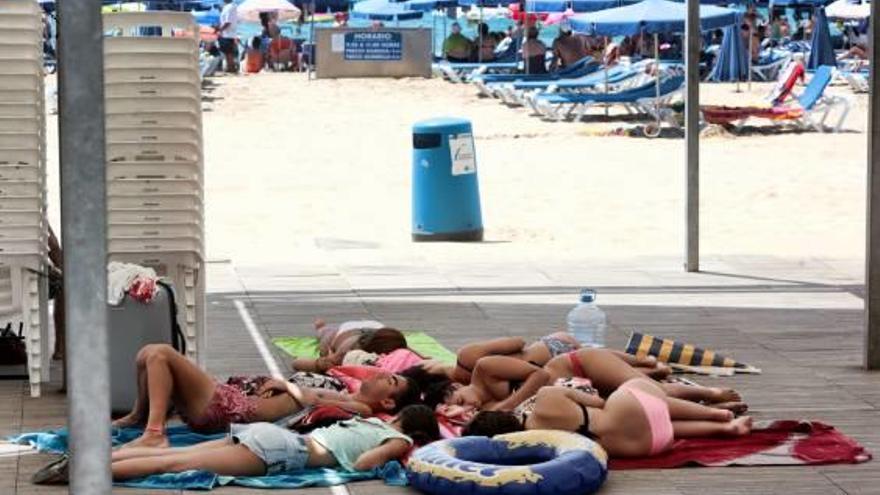 Un grupo de jóvenes duerme en una playa de Benidorm.