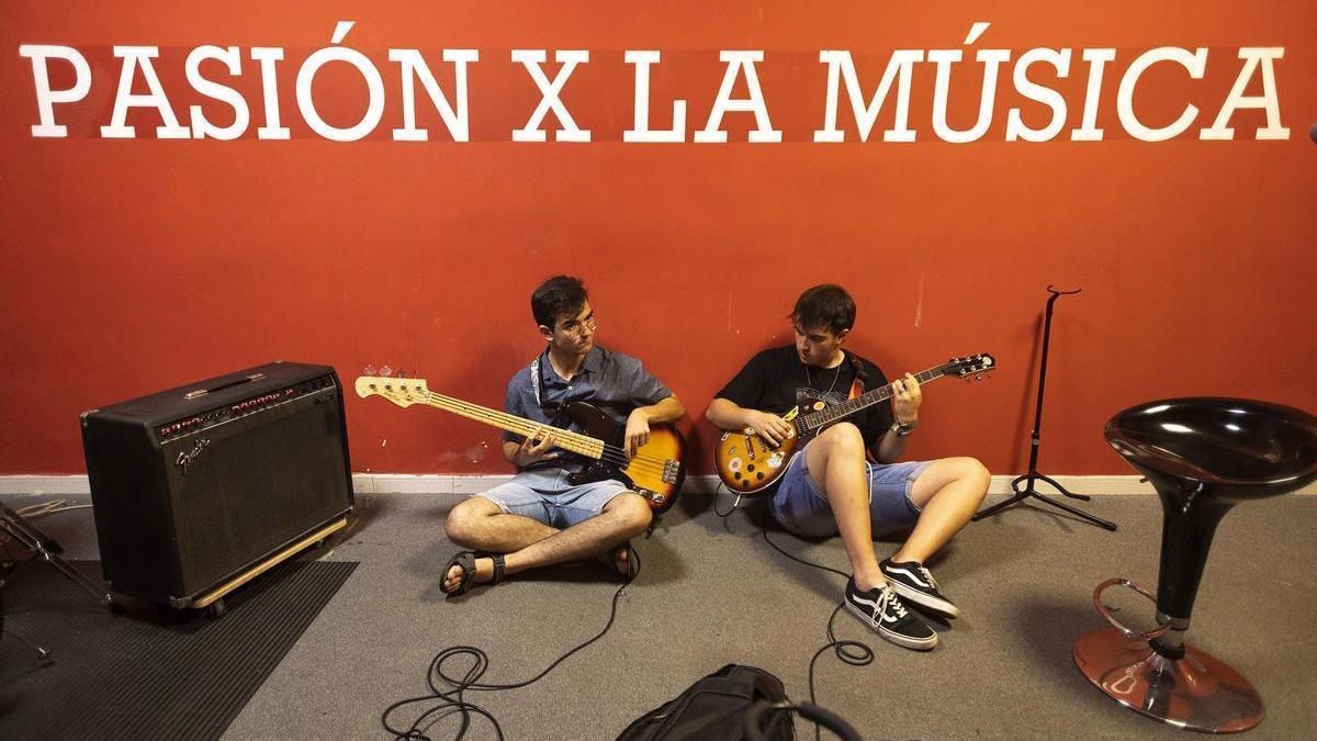 Dos jóvenes de Zona Azul ensayando con sus instrumentos en una de las instalaciones disponibles.