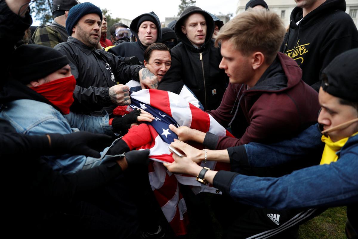 Counter-demonstrators (L) and supporters (R) of U.S. President Donald Trump fight for a U.S. flag during a People 4 Trump rally in Berkeley, California March 4, 2017. REUTERS/Stephen Lam