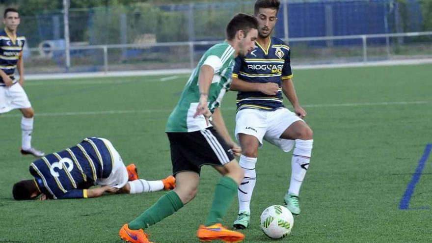 Ernesto presiona al jugador del Lenense Pablo Sánchez con Noel Alonso en el suelo.