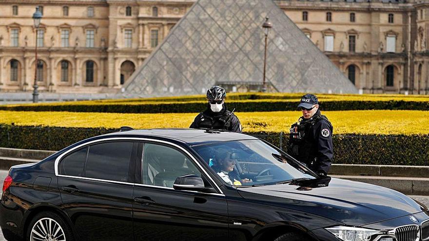 Agents policials revisen un cotxe fora del Museu del Louvre.