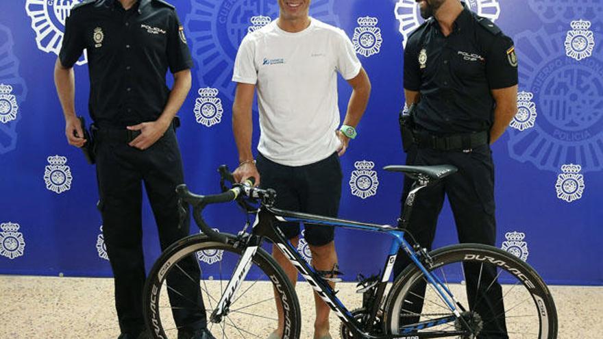 Óscar Quintana , representante legal del equipo Orica Greenedge, inscrito en la Vuelta Ciclista a España 2015, posa junto a los dos agentes de la Policía Nacional que han recuperado la bicicleta del equipo australiano.
