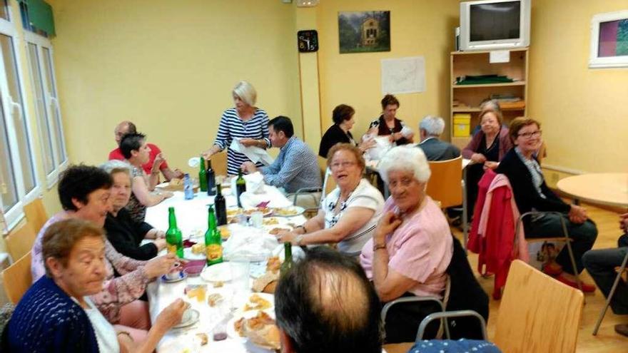 Los vecinos disfrutan de la comida en las antiguas escuelas de Villardeveyo.