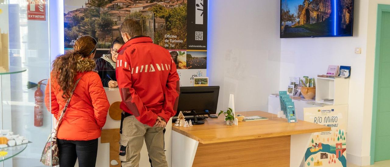 Dos visitantes, en la oficina de turismo de Tui.