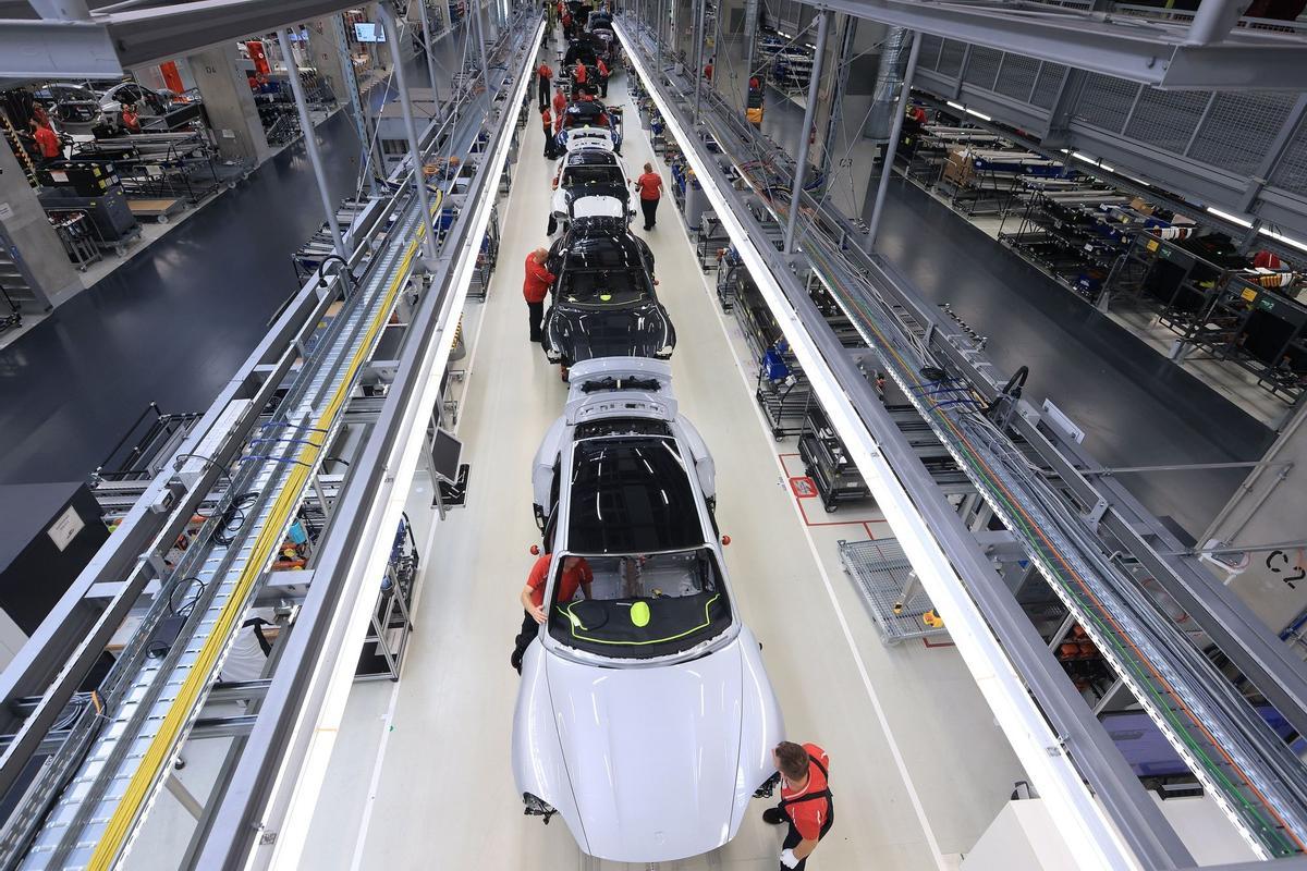 Los empleados trabajan en las carrocerías de los automóviles de lujo Porsche Taycan totalmente eléctricos en la línea de producción de la fábrica de Porsche AG en Stuttgart, Alemania.