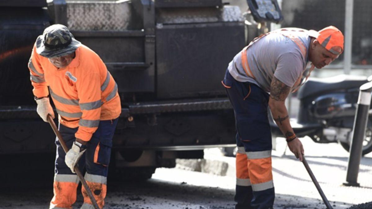 Operadores realizando trabajos de asfaltado en una vía urbana