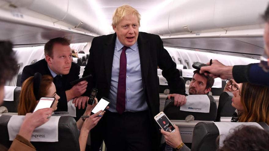 Boris Johnson charla con los periodistas en un avión.